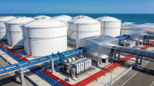 Coastal water treatment and desalination plant with potable water tanks, RO process buildings, brine pipelines, and corrosion-protected steel structures.